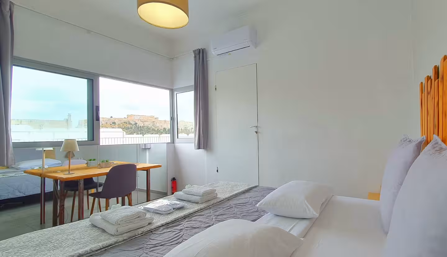 Bedroom with large window overlooking the Acropolis by day
