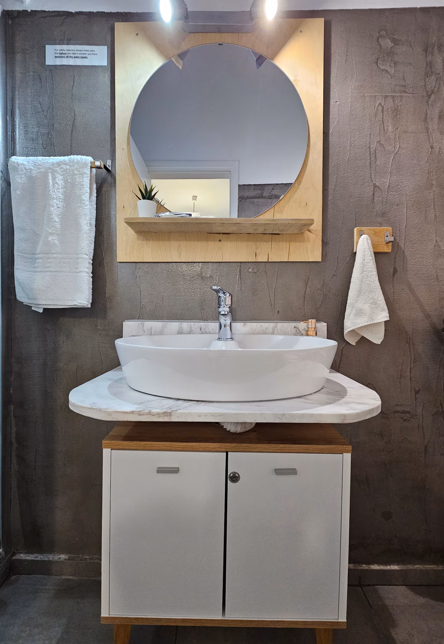 Bathroom vanity with round mirror and marble countertop